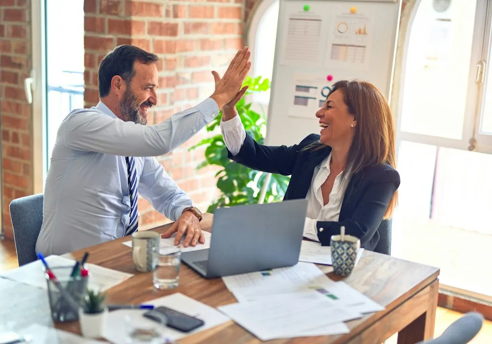 Two colleagues celebrating a completed job with a high five