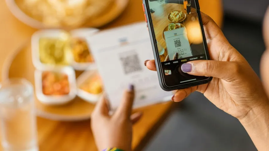A hand holding a phone, taking a photo of a paper receipt