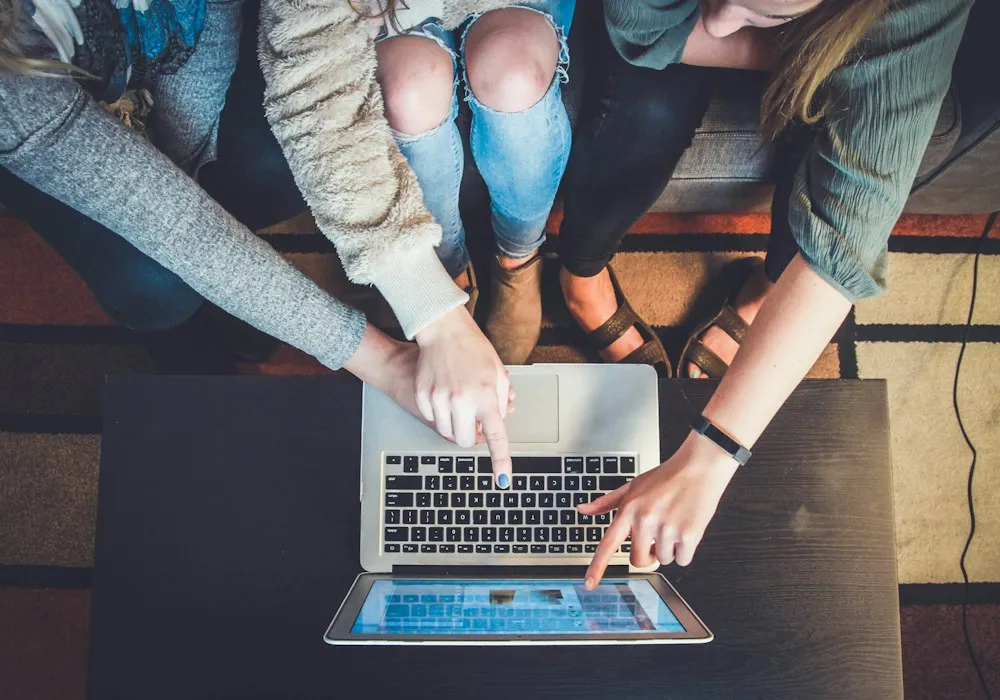 Two people reviewing invoices and payments together on a laptop